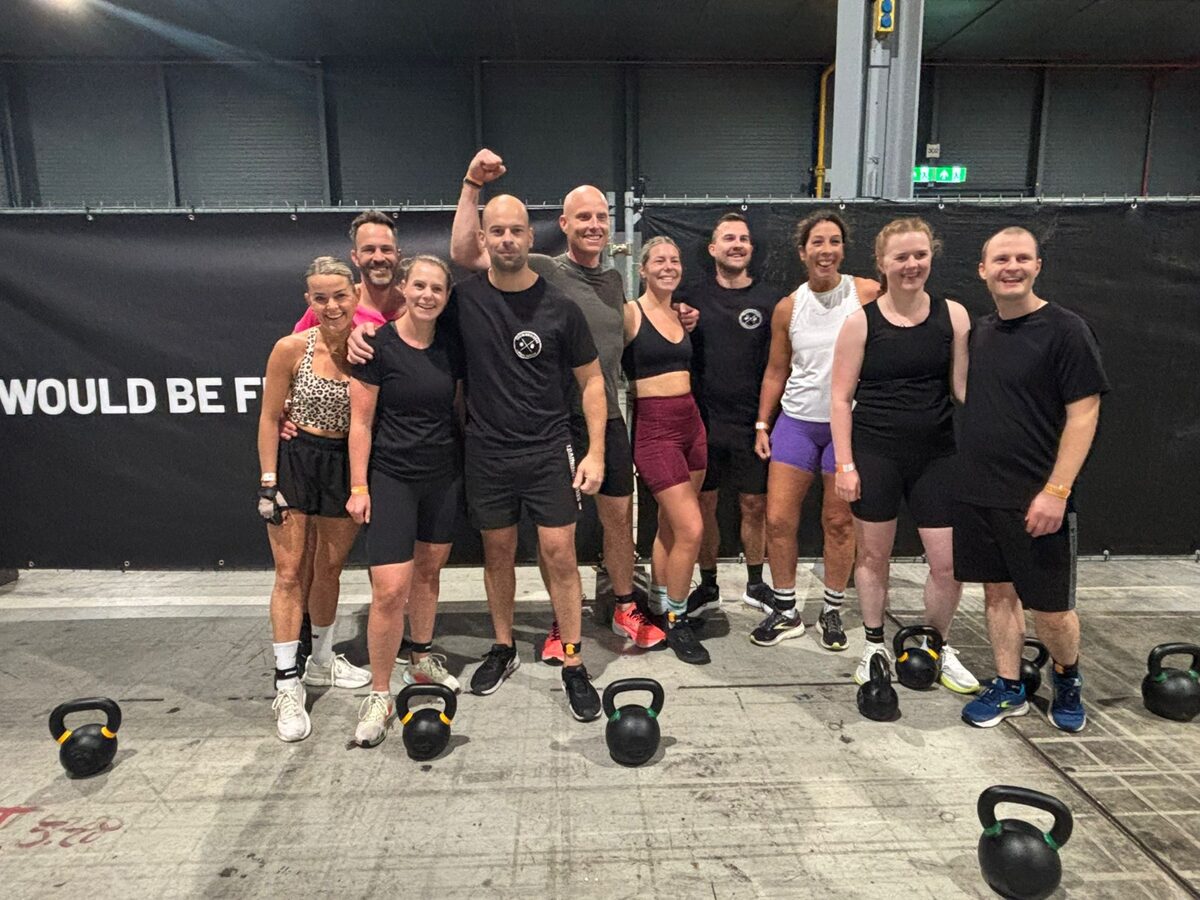 De groep van Trainingsloods Ede samen op het Gym Race-event, met kettlebells op de voorgrond